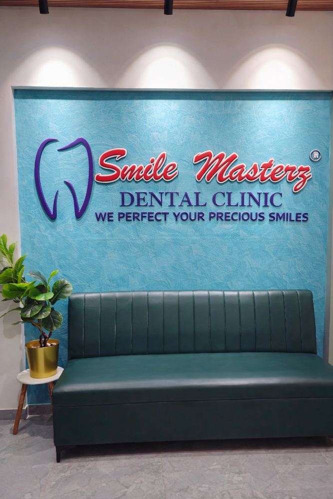 Reception and waiting area with the Smile Masterz Dental Clinic logo wall